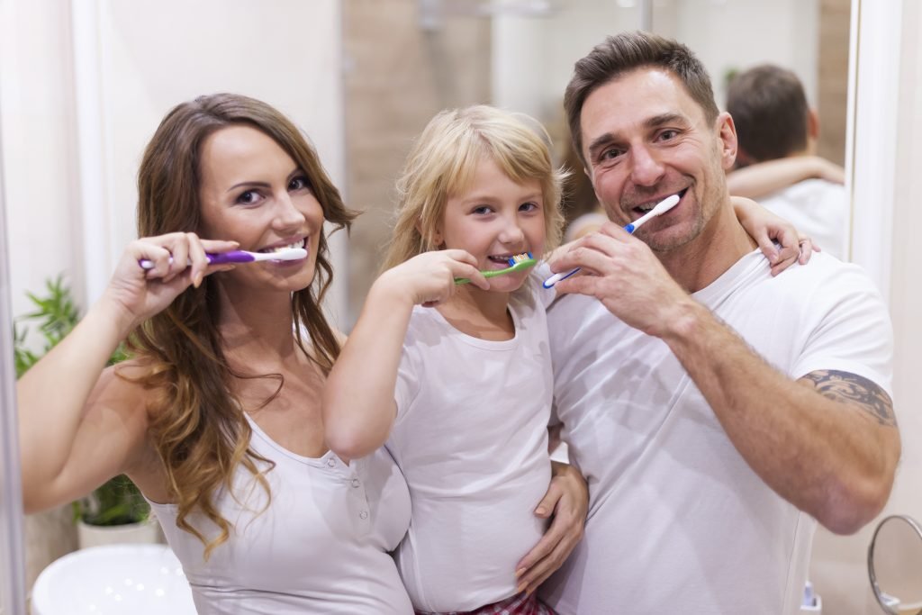 cepillandose una familia para lograr una buena higiene oral