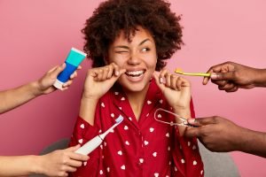 Mujer con diferentes tipos de intrumentos para una buena higiene oral