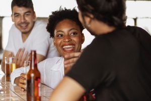 Chica sonriendo y bebiendo alcohol en el marco del Día Mundial Sin Alcohol